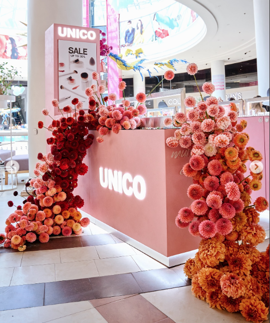 Comptoir de boutique encadré de cascades de fleurs rouges, roses et orangées