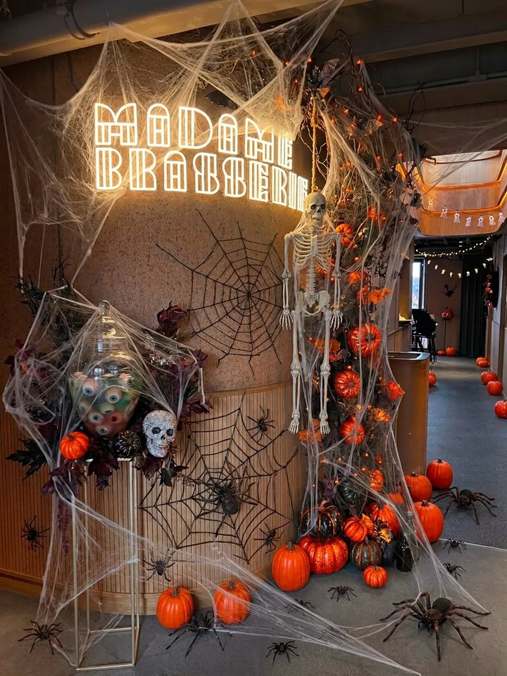 L’entrée de Madame Brasserie décorée pour Halloween : toiles d’araignée, squelette et citrouilles sous l’enseigne lumineuse