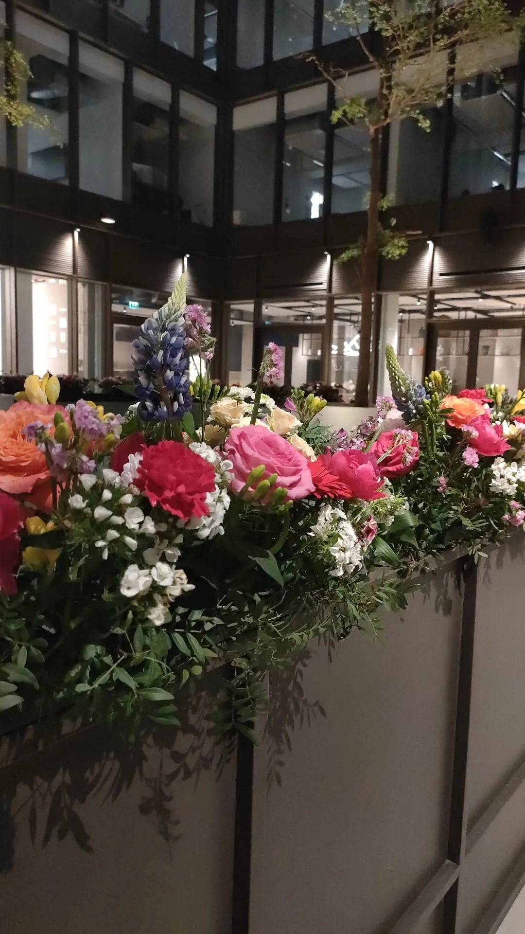 Jardinière du hall garnie de roses, d’œillets et de lupins