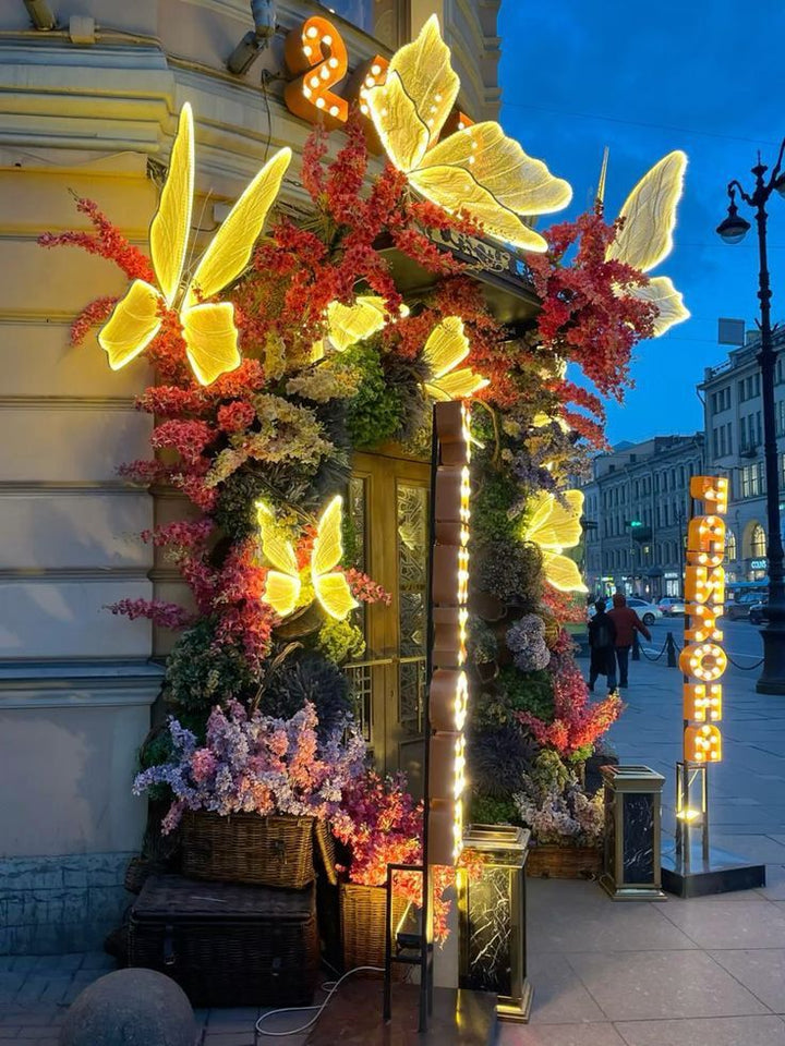 Façade de boutique encadrée de fleurs et de papillons lumineux