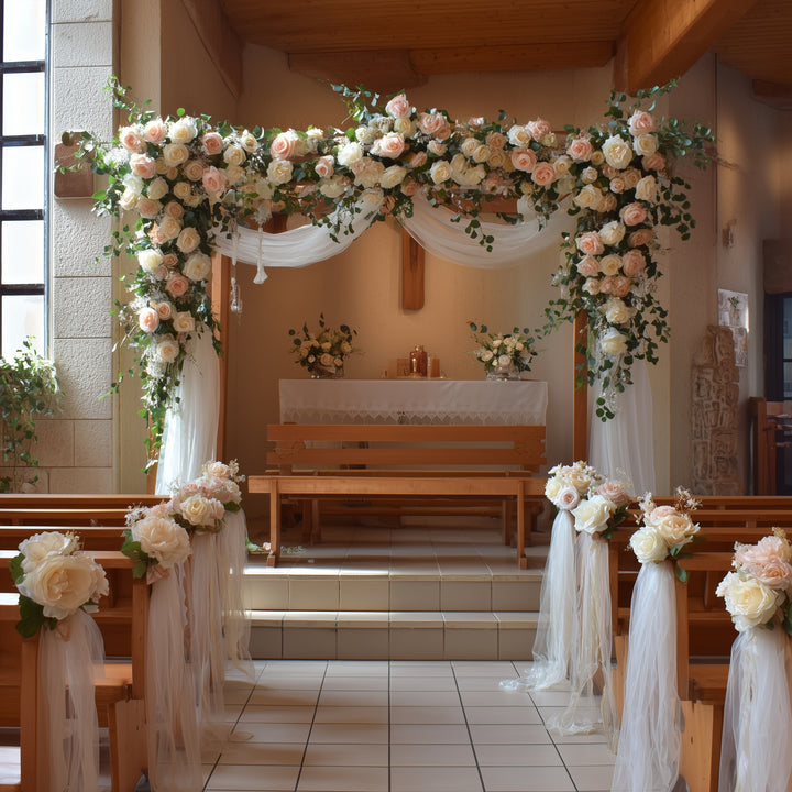 Arche de fleurs blanches et roses au-dessus d’un autel, bancs ornés de fleurs